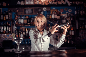 Charismatic woman bartender demonstrates his professional skills while standing near the bar counter in bar
