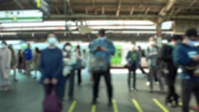SHINJUKU, TOKYO, JAPAN : Crowd of people at railway or train platform. Commuters waiting for train in busy morning rush hour. Japanese city life and transportation concept. Blurred slow motion shot.