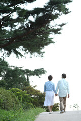 Fototapeta premium 공원에서 손을잡고 산책하는 커플