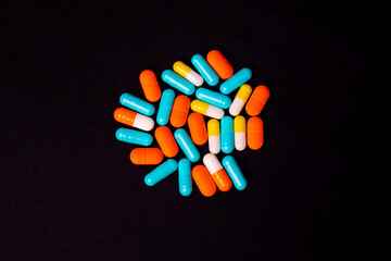 Multicolored pills close up on black isolated background