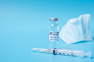 COVID-19 Vaccine vial, injection Needle Syringe and Face mask against Coronavirus infection in hospital laboratory. Medical, health, Vaccination and immunization concept