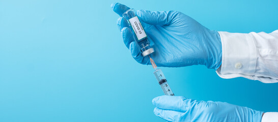 COVID-19 Vaccine vial and injection Needle Syringe against Coronavirus infection in hand of doctor with Nitrile Glove in hospital laboratory. Medical, health, Vaccination and immunization concept