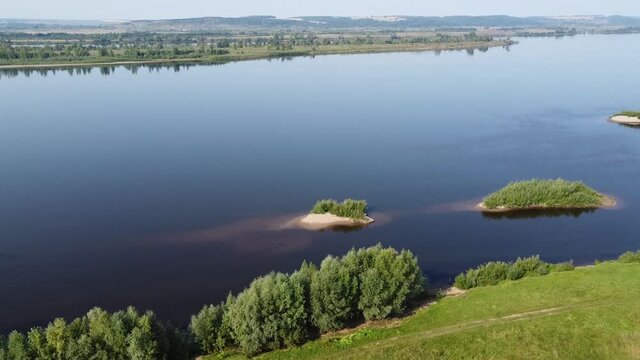 Top view of a wide full-flowing river with islands. Summer sunny day. Aerial photography