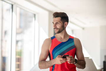 Sporty man in bright tshirt looking at the window