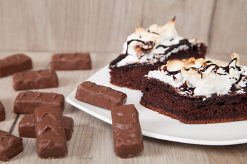 Delicious chocolate candies with cake on a wooden background.