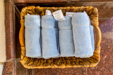 Clean blue towels in a basket in a hotel for guests