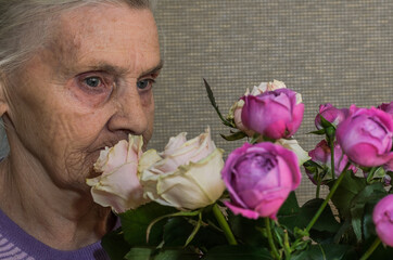 Elderly woman with bouquet of flowers roses	