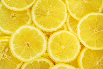 Fruit background, top view. Juicy yellow lemon cut into round slices.
