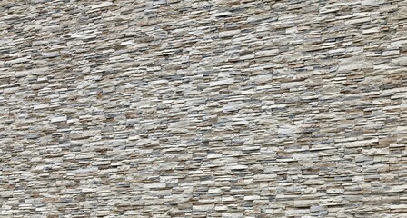 Large stone cladding wall made of striped stacked slabs of natural brown, gray and white rocks....