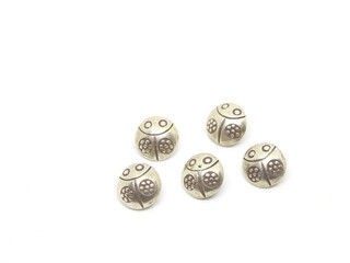 Silver ladybug buttons on white background.