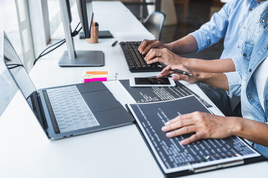 Two professional programmer cooperating and working on web site project in a software developing on desktop computer at company, codes and typing data code, Programming with HTML, PHP and javascript