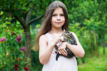 lovely kitty. small girl hold cute cat in hands. kid love her pet. human and animals. love and care. fluffy kitten in hand of pretty child. little beauty outdoor with pet. happy childhood. pet lover