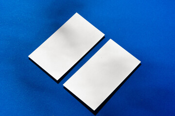 Two stacks of blank businesscards on blue background