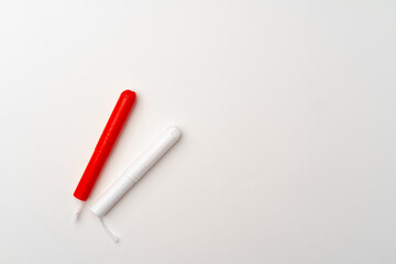 Red and white woman medical tampons on white background