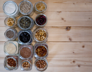 Seed,nut and dried fruits in various jars over wood background.
