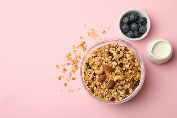 Concept of tasty breakfast with granola on pink background