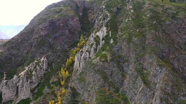 Aerial dolly shot of Natural Boundary Akkurum with scenic rock formations Stone mushrooms in the Karasu gorge of the Altai reserve in Chulyshman river valley with unrecognized tourists walking around 