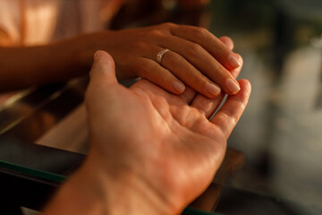  Romantic couple holding each other's hand at dinner in a luxury restaurant. Marriage proposal and engagement concept.
