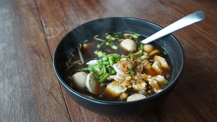 Traditional pork ball and Vietnamese Pork Sausage vermicelli  noodle soup Thai north eastern style on black bowl