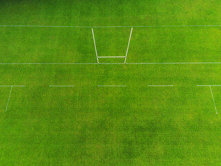 Rugby and Irish national sports camogie, hurling, gaelic football tall goal posts in a green grass training field. Aerial drone view. - obrazy, fototapety, plakaty