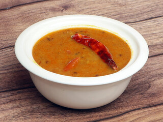 Authentic Indian popular food Dal Tadka Curry or Traditional Indian soup lentils on rustic wooden background. selective focus