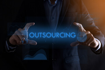 Business man hands holding inscription OUTSOURCING with different graphs on the...