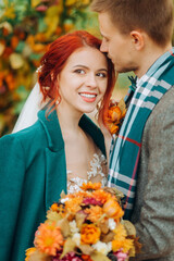 Portrait of a young couple near the wedding arch. Redhead girl and handsome guy hug each other.