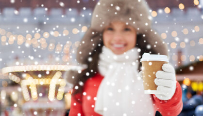 people, hot drinks and winter holidays concept - happy woman drinking coffee over christmas market on background