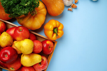 Pumpkins, apples and bell pepper composition on blue background