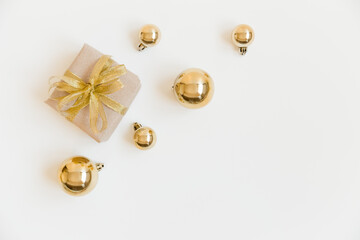 Christmas flat lay with craft gift box and golden Christmas balls on the white background. Christmas decoration. Winter, New Year and Christmas concept