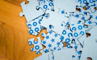 Close-up blue puzzles of different sizes lying on a wooden surface - 393797598