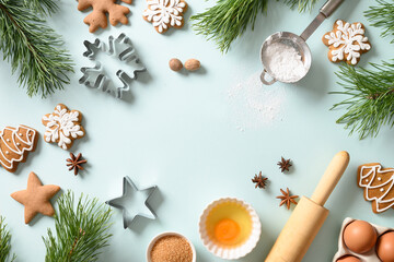 Christmas gingerbread cookies with ingredients for cooking in light blue background. Merry Christmas and Happy New Year. Copy space
