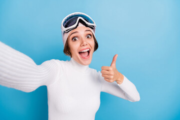 Photo of pretty brunette bob haired skier girl show thumb up make selfie wear white sweater excited...