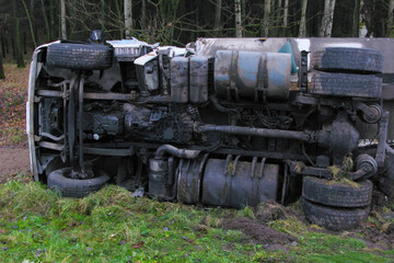 Fototapeta na wymiar daylight. fall. A white truck with a trailer lies in a ditch turned over on its right side. Vehicle damage