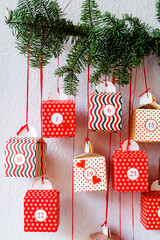 Handmade advent calendar red gift boxes hanging on the wall. Sustainable Christmas,  zero waste,...