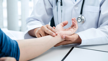 The doctor hold the patient on the wrist to take the pulse heart rate