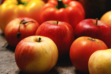 Pile of apples and bell peppers on wooden table
