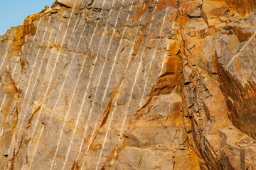 Rock layers - a colorful formations of rocks stacked over the hundreds of years, rough texture. Stones texture and background. Rock texture and boulders piled on the beach