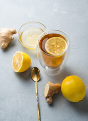 Healthy living herbal tea; lemon honey tea with ginger root on a gray background