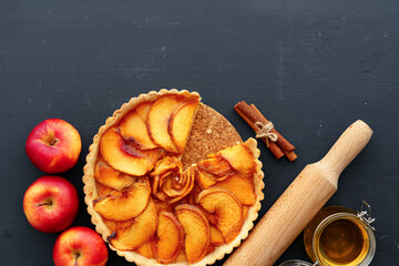 Apple tart pie and red apples on wooden table