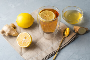 Healthy living herbal tea; lemon honey tea with ginger root on a gray background