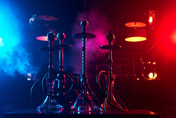 hookahs on the table with smoke and red and blue light in the lounge cafe