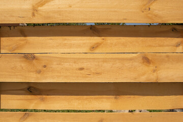 boards horizontally, wooden fence made of boards and green grass