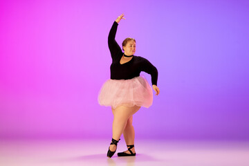 Lightful. Beautiful caucasian plus size model practicing ballet dance on gradient purple-pink studio background in neon light. Concept of motivation, inclusion, dreams and achievements.