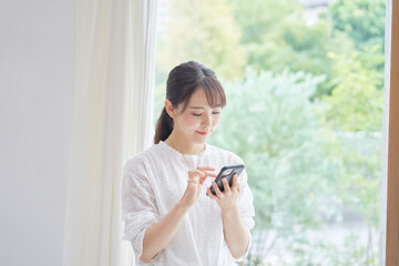 リビングでスマホを使う女性