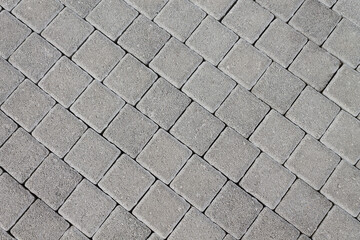 Pavement made of natural stone in the form of tiles. Texture background for designers.
