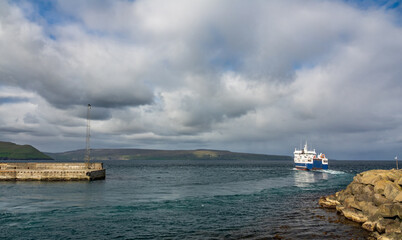 Large boat leaves the port under cloudy sky