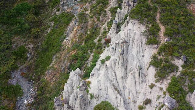 Aerial dolly shot of Natural Boundary Akkurum with scenic rock formations Stone mushrooms in the Karasu gorge of the Altai reserve in Chulyshman river valley with unrecognized tourists walking around 