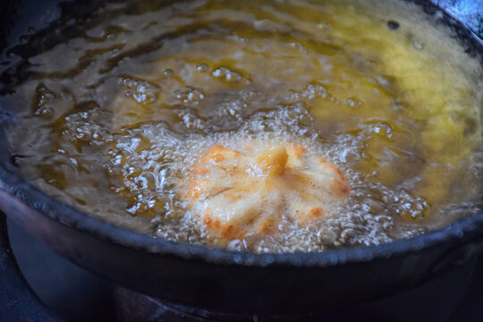 Picture of frying modak or sweet mo-mos in ghee . Modak made during the Ganpati festival in maharashtra
