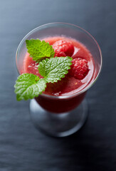 Fresh smoothie in a glass. Dark background. Close up.